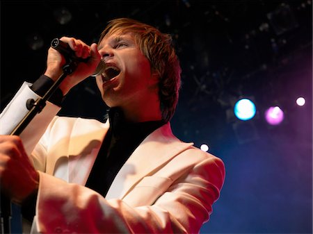 simsearch:693-03302042,k - Young Man Singing into microphone on stage at Concert, low angle view Stock Photo - Premium Royalty-Free, Code: 693-03302042