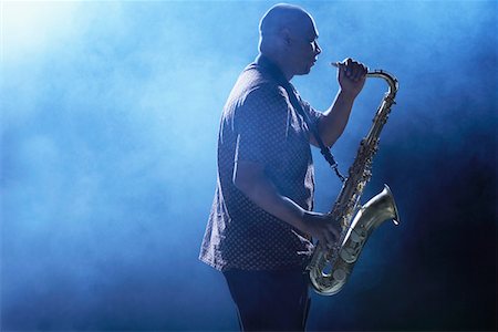 photos of man playing saxophone - Man Playing Saxophone in smoky place, side view Stock Photo - Premium Royalty-Free, Code: 693-03302070