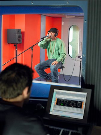 rap - Young man singing in studio, technician in foreground Fotografie stock - Premium Royalty-Free, Codice: 693-03302081