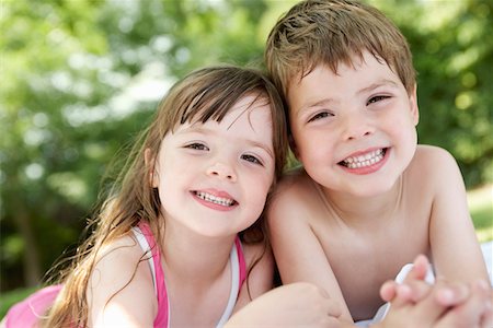 Boy and girl lying in backyard, portrait, close up Stock Photo - Premium Royalty-Free, Code: 693-03302119