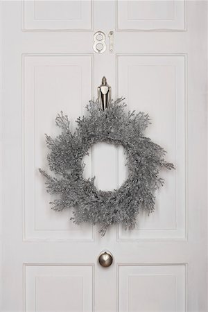 Couronne de Noël accroché sur la porte blanche Photographie de stock - Premium Libres de Droits, Code: 693-03302141