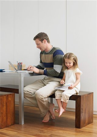 Father and daughter drawing and using laptop Stock Photo - Premium Royalty-Free, Code: 693-03302334