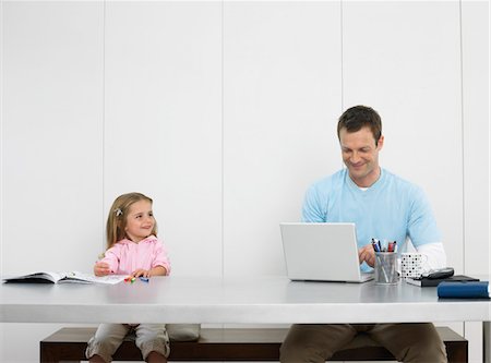 Father and daughter drawing and using laptop Stock Photo - Premium Royalty-Free, Code: 693-03302341