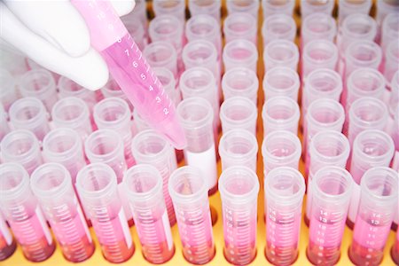 Lab worker adding violet liquid to test tubes Foto de stock - Sin royalties Premium, Código: 693-03302517