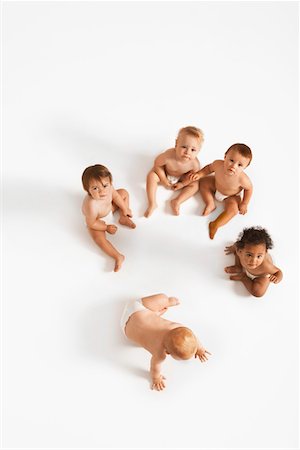 Over head shot of small group of babies in white studio Stock Photo - Premium Royalty-Free, Code: 693-03302571