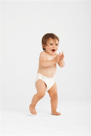 Bambin excité en prenant la première étapes de studio blanc Photographie de stock - Premium Libres de Droits, Code: 693-03302598