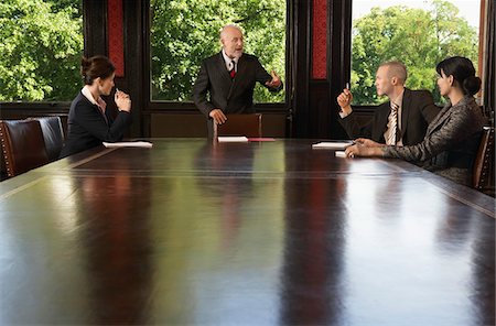 Businesspeople meeting around boardroom table, businessman standing Stock Photo - Premium Royalty-Free, Code: 693-03302612