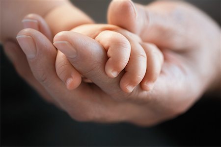 father holding a baby in his hands - Baby holding man's finger, close up of hands Stock Photo - Premium Royalty-Free, Code: 693-03302888