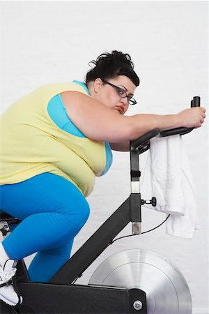 side profile woman chubby - Overweight Woman on Exercise Bike Stock Photo - Premium Royalty-Free, Code: 693-03302947