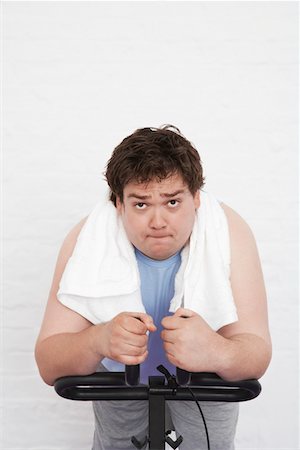 Overweight man on Exercise Bike, portrait Stock Photo - Premium Royalty-Free, Code: 693-03302949