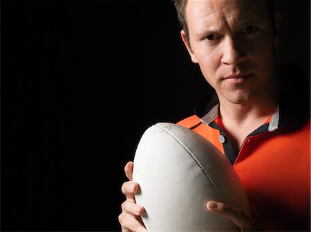 Rugby player holding ball, close-up, portrait Stock Photo - Premium Royalty-Free, Code: 693-03302994