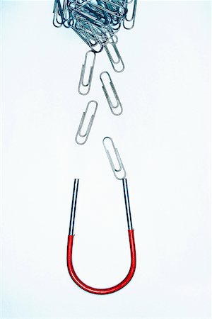 Horseshoe magnet attracting paperclips, in studio Stock Photo - Premium Royalty-Free, Code: 693-03303034