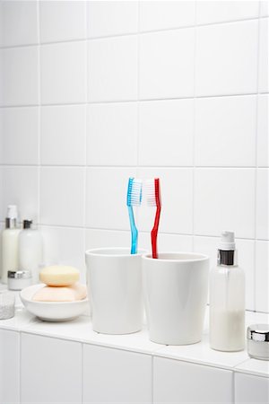 Toothbrushes face to face on shelf in white bathroom Foto de stock - Sin royalties Premium, Código: 693-03303074