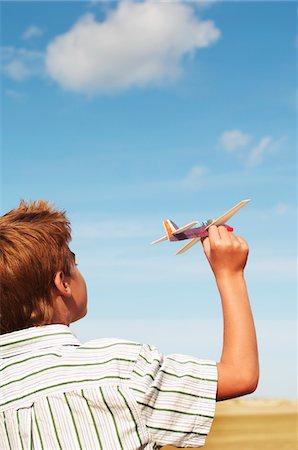 simsearch:400-04016912,k - Boy standing on beach Flying Toy Airplane, back view Foto de stock - Sin royalties Premium, Código: 693-03303113