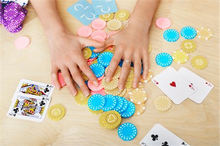 Hands of woman Grabbing Gambling Chips on table, close up of hands, overhead view Stock Photo - Premium Royalty-Free, Code: 693-03303145