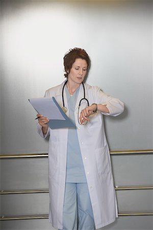 Physician Checking Wristwatch in elevator Stock Photo - Premium Royalty-Free, Code: 693-03303171