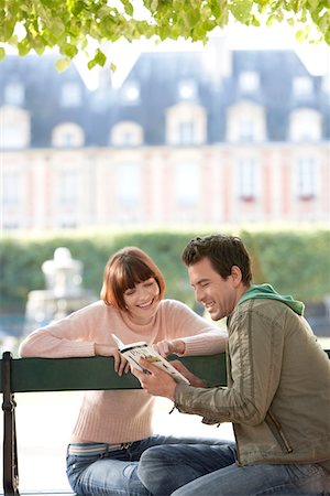 paris lovers bench - Young couple reading guide book, sitting on bench in park Stock Photo - Premium Royalty-Free, Code: 693-03303350