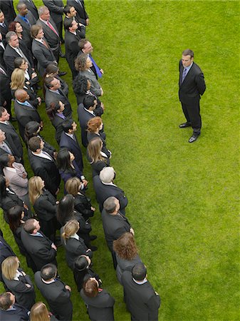exclusion business - Business man facing large group of business people in formation, elevated view Stock Photo - Premium Royalty-Free, Code: 693-03303468