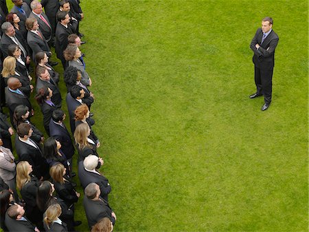 exclusion business - Business man facing large group of business people in formation, elevated view Stock Photo - Premium Royalty-Free, Code: 693-03303472
