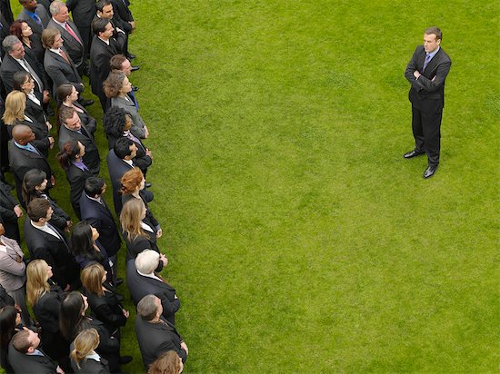 Business man facing large group of business people in formation, elevated view Stock Photo - Premium Royalty-Free, Image code: 693-03303472