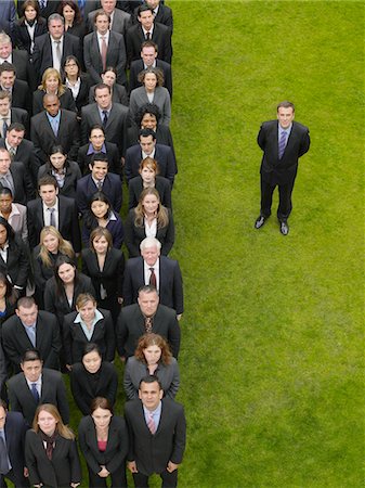 Business man standing next to large group of business people in formation, elevated view, portrait Stock Photo - Premium Royalty-Free, Code: 693-03303473