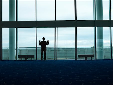 people airports silhouettes - Businessman standing, Looking out Window, back view Stock Photo - Premium Royalty-Free, Code: 693-03303507