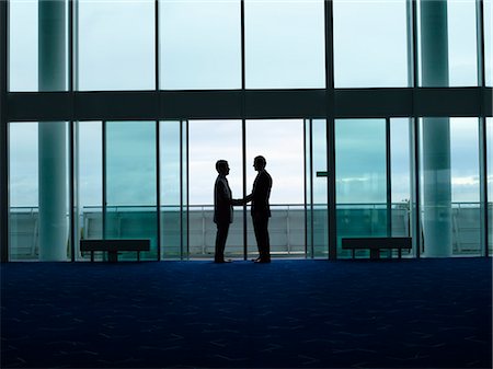 Businessmen Shaking Hands in doorway, silhouette, profile Stock Photo - Premium Royalty-Free, Code: 693-03303508