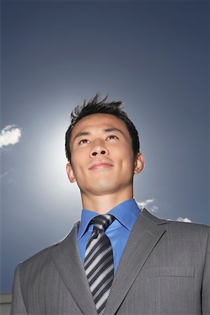Smiling, Young Businessman standing outside, low angle view Stock Photo - Premium Royalty-Free, Code: 693-03303514