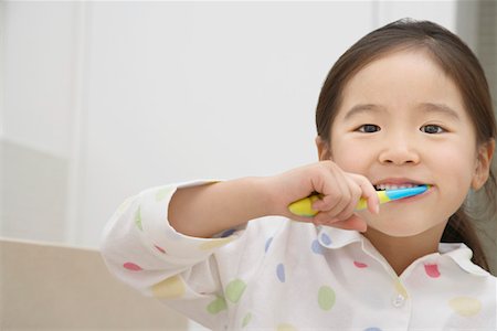 Young Girl in pyjamas Brushing Her Teeth Stock Photo - Premium Royalty-Free, Code: 693-03303540