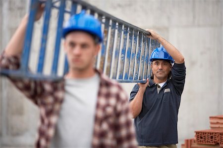 Two construction workers carrying ladder Stock Photo - Premium Royalty-Free, Code: 693-03303623