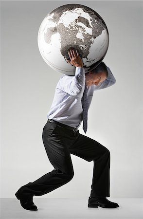 Businessman struggling, carrying globe on shoulders, side view Stock Photo - Premium Royalty-Free, Code: 693-03303631
