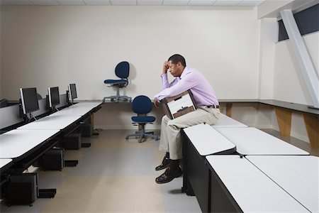 Depressed Man Sitting on Desk with Moving Box Stock Photo - Premium Royalty-Free, Code: 693-03314148
