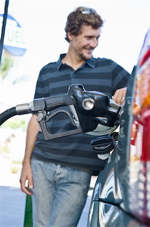 Smiling man refueling car at natural gas station Foto de stock - Sin royalties Premium, Código: 693-03314217