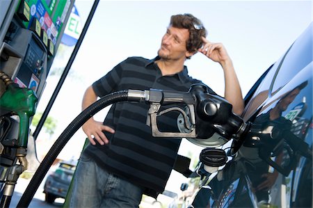 environment gas - Smiling man refueling car at natural gas station Stock Photo - Premium Royalty-Free, Code: 693-03314218