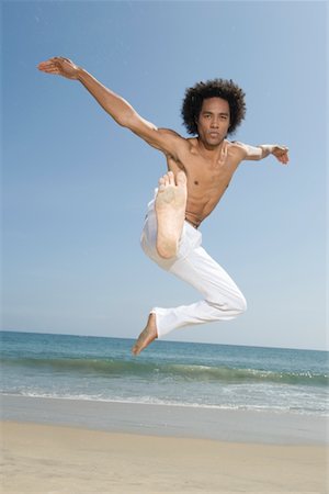 Young man exercising on beach Stock Photo - Premium Royalty-Free, Code: 693-03314311