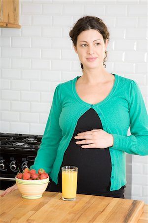 pensive mature brunette woman looking away - Pregnant woman in kitchen Stock Photo - Premium Royalty-Free, Code: 693-03314526
