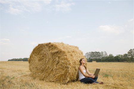 fardo de heno - Young woman using laptop agaist hay bale in field Foto de stock - Sin royalties Premium, Código: 693-03314986
