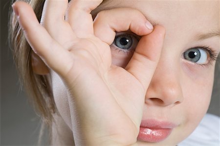 preteen girls faces close ups - Studio portrait of girl peeking through hand, close-up Stock Photo - Premium Royalty-Free, Code: 693-03315104