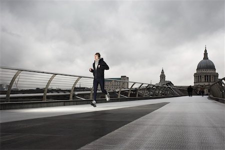 fit person running low angle - Young male runner on the Millenium Bridge with St Paul's in the background Stock Photo - Premium Royalty-Free, Code: 693-03315187