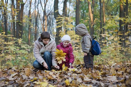 Mother collecting leaves with children in park Stock Photo - Premium Royalty-Free, Code: 693-03315254