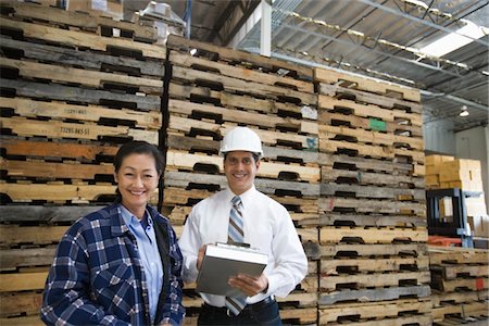 simsearch:693-03315346,k - Woman and man standing in distribution warehouse, portrait Stock Photo - Premium Royalty-Free, Code: 693-03315329