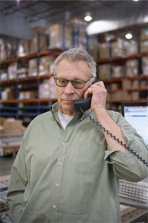 simsearch:693-03315336,k - Serious man using telephone in distribution warehouse Stock Photo - Premium Royalty-Free, Code: 693-03315337