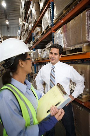 simsearch:693-03315379,k - Woman and man talking in distribution warehouse Foto de stock - Royalty Free Premium, Número: 693-03315333