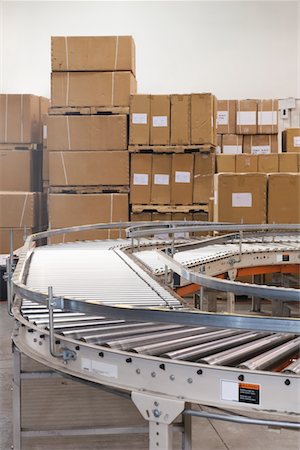 factory box conveyor belt - Cardboard boxes and conveyor belt in distribution warehouse Stock Photo - Premium Royalty-Free, Code: 693-03315355