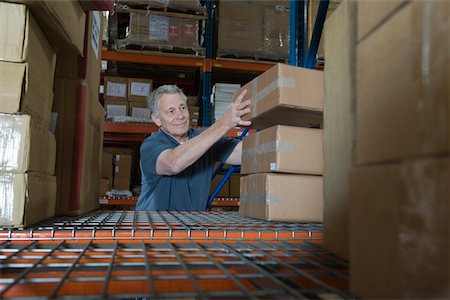 simsearch:693-03315346,k - Man stacking boxes in distribution warehouse Stock Photo - Premium Royalty-Free, Code: 693-03315378