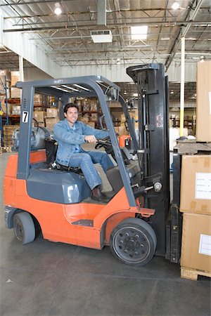 simsearch:693-03315346,k - Man operating fork lift truck in distribution warehouse Stock Photo - Premium Royalty-Free, Code: 693-03315381
