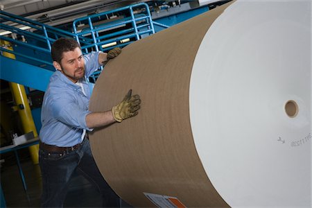 press manufacture - Man pushing huge roll of paper in newspaper factory Stock Photo - Premium Royalty-Free, Code: 693-03315440