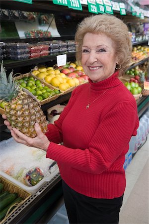 simsearch:693-03315577,k - Senior woman holding pineapple in supermarket Foto de stock - Royalty Free Premium, Número: 693-03315576