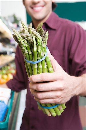 Young man holding asparagus in supermarket Stock Photo - Premium Royalty-Free, Code: 693-03315581