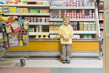 Young boy standing by fridge counter of supermarket Stock Photo - Premium Royalty-Free, Code: 693-03315606